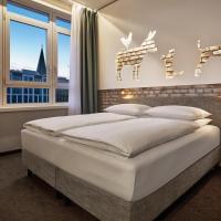 a bedroom with a large white bed and a window at H+ Hotel Bremen