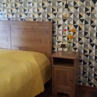 a bedroom with a yellow bed and a side table at B&B del Lago, Ispra