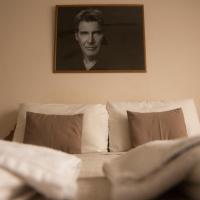 a bedroom with a bed with a portrait of a man at Hotel de Cine Las Golondrinas, Villa Gesell