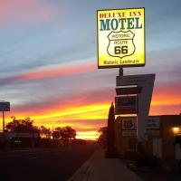 a gas station with a sign in front of a sunset at Deluxe Inn, Seligman