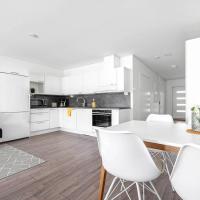 a kitchen with white cabinets and a table and chairs at Hämeentie Apartments, Järvenpää