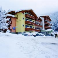 a snow covered building with people walking in front of it at Hotel Bonapace ***S, Madonna di Campiglio