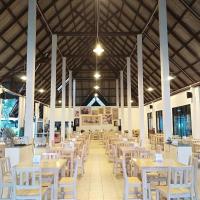 a dining hall with tables and white chairs at LayTrang Pakmeng Marina Spa and Resort