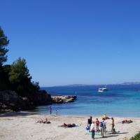 a group of people on a beach with a boat in the water at Villa Bosque, Cala Blava