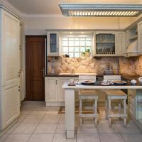 a kitchen with white cabinets and a island with stools at My Apartment Corfu, Potamós