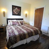 a bedroom with a bed and a wooden floor at Rustic Inn, Abbeyshrule