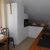 a kitchen with a table and a white refrigerator at Pokoje gościnne Barka, Wadowice