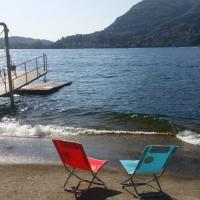 two chairs sitting on the beach next to a dock at Beautiful Lake Como Bilocale, Blevio