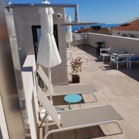 a balcony with chairs and a umbrella and tables at HOTEL TORRENT, L'Escala