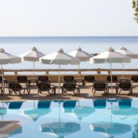 a pool at the beach with umbrellas and chairs at Harmony Bay Hotel, Limassol