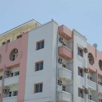 an apartment building with pink at Comfort Hotel, Djibouti