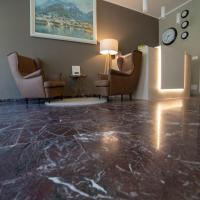 a living room with chairs and a marble floor at Hotel Moderno, Lecco