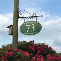 a sign hanging from a pole next to flowers at Privatquartier 73, Wietzen