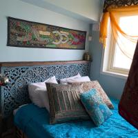 a bedroom with a bed with blue sheets and a window at FlipFlop Beach Bar & Rooms, Falkenberg