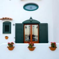 a white building with a clock and two potted plants at MARINELLA CASA VACANZE, Cetara