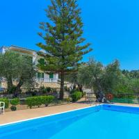 a swimming pool in front of a house with a tree at Fran Apartments, St. Spyridon Corfu
