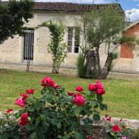 a house with red roses in front of a yard at Chez Lysette, Mesnac