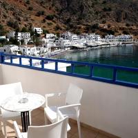 a balcony with a table and chairs and a view of a harbor at Loutro Holidays