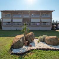 a building with two large rocks in a yard at Camping Linaraki Apartments & Bungalows, Sykia Chalkidikis
