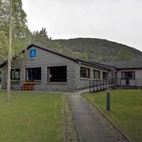 a stone building with a grass yard in front of it at Aviemore Youth Hostel