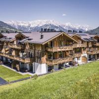 an aerial view of a house with mountains in the background at Stockinggut by AvenidA Hotel & Residences Leogang