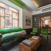 a living room with a green couch and two green chairs at Hotel Button, Parma