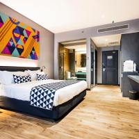 a bedroom with a king sized bed and a flat screen tv at TROVE Johor Bahru