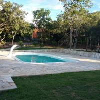 a swimming pool in a yard with a stone patio at Pousada e Restaurante Maria das Flores, Três Marias