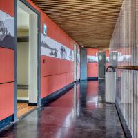 a corridor of a building with red walls at Le Merceny Motel, Bastogne
