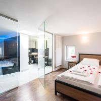 a bedroom with a bed and a bathroom with a tub at Exclusive Apartment Centrum, Wadowice