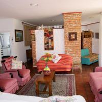 a living room with pink furniture and a brick wall at Fleming Place, Bulawayo