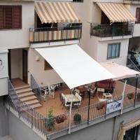 an apartment balcony with a white awning and tables and chairs at B&B Carol, Cetara