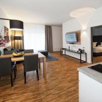 a living room with a table and a room with a bed at Rivers Passau