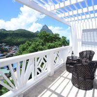 a balcony with a table and chairs and a view of the mountains at Sugarmon Villas, Soufrière