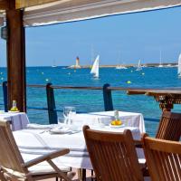 a restaurant with a view of the water and boats at Hotel Brismar, Port d'Andratx