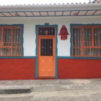 a red and white building with a red door and windows at LA CASA MARROQUÍ, Pijao