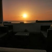 a sunset over the ocean from a balcony with couches at Apartamentos Flor del Cotillo, El Cotillo
