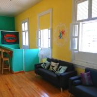 a living room with two couches and two windows at Park Hostel, Port-au-Prince
