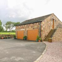 a stone building with a garage with two doors at The Croft, Chorley