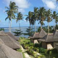 a view of a resort with thatched roofs and the ocean at Jonas and Twins Resort, General Luna