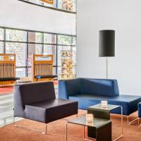 a lobby with two blue chairs and a table at IntercityHotel Erfurt