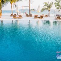 a swimming pool with chairs and the ocean in the background at Scarlet Sails Resort, Koh Rong Island