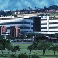 a large white building with trees in front of a city at Eurobuilding Hotel & Suites Caracas