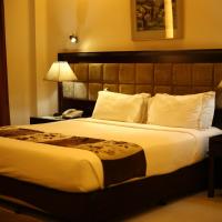 a hotel room with a large bed and two lamps at THE AVENUE HOTEL & SUITES, Chittagong