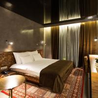 a bedroom with a bed and a table and a chair at Hotel Hemera, Podgorica