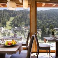 a table with a bowl of fruit in a room with a view at Hotel Garnì Caminetto, Madonna di Campiglio