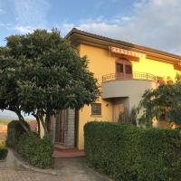 a yellow house with a balcony and trees at Il Nespolo, Cavriglia