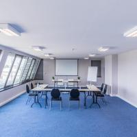 a conference room with tables and chairs and windows at Holiday Inn Express Lisbon Airport, an IHG Hotel