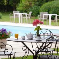 a table with a vase of flowers on it next to a pool at Logis Auberge Saint Simond, Aix-les-Bains