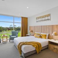 a bedroom with a large bed and two chairs at Parkside Motel Geelong